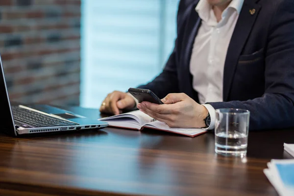 Empresário segurando um telefone celular e escrevendo mensagem sms no escritório, empresário usar telefone inteligente móvel, Fechar-se de um homem usando telefone celular, Jovem empresário trabalhando com dispositivos modernos telefone móvel . — Fotografia de Stock