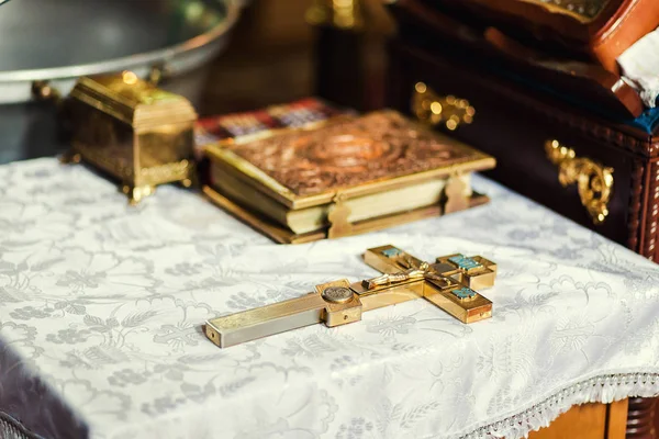 Ustensile d'église sur un autel, gland, croix sur l'autel de l'église, la Bible sur la table, cérémonie du baptême d'eau, prêtre orthodoxe tient une bible sur une table avec divers objets nécessaires au baptême — Photo