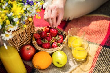 Çimlerde piknik. suyu, bir demet kır çiçekleri, meyve, ot, sağlıklı yiyecek ve aksesuarları, piknik çim yaz saati dinlenme Parkta piknik 