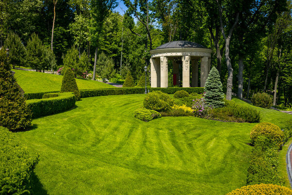 Landscaping in the garden. The path in the garden.Beautiful backyard landscape design,Some flowers and nicely trimmed bushes on the leveled front yard,Landscape formal