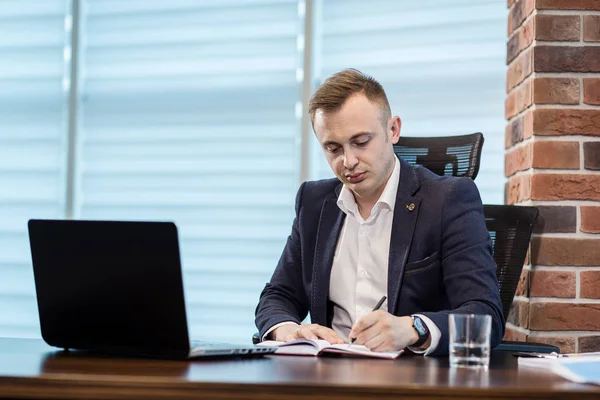 businessman sitting behind a laptop,Serious businessman sitting behind a table on his laptop,Businessman Working Laptop Connecting Networking Concept