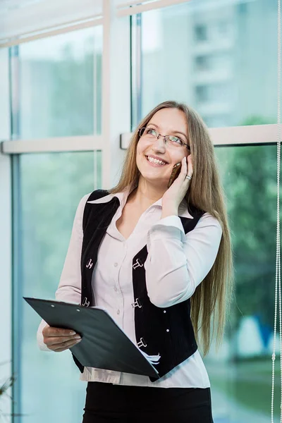 A businesswoman talking on a mobile phone,woman talking on the phone in office,Portrait of businesswoman talking on mobile phone,business concept