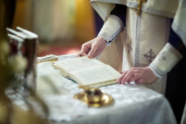 Εκκλησιαστικά σκεύη σε ένα βωμό, βάλανο, Σταυρός στον βωμό εκκλησία, η Αγία Γραφή πάνω στο τραπέζι, η τελετή του βαπτίσματος, ορθόδοξος ιερέας κατέχει μια Αγία Γραφή σε ένα τραπέζι — Φωτογραφία Αρχείου
