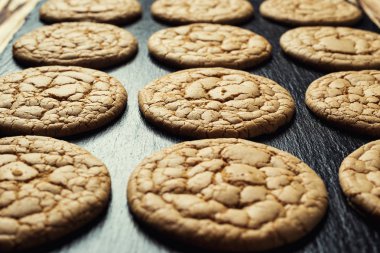 Bisküvi tatlı kurabiye arka plan. Yerli yığılmış tereyağı bisküvi desen kavramı, makro yakından. Ev yapımı kurabiye ahşap masa üzerinde. Mısır gevreği bisküvi susam, yer fıstığı, ayçiçeği ve amaranth.