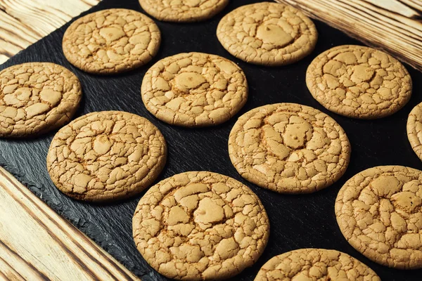 Bisküvi tatlı kurabiye arka plan. Yerli yığılmış tereyağı bisküvi desen kavramı, makro yakından. Ev yapımı kurabiye ahşap masa üzerinde. Mısır gevreği bisküvi susam, yer fıstığı, ayçiçeği ve amaranth.