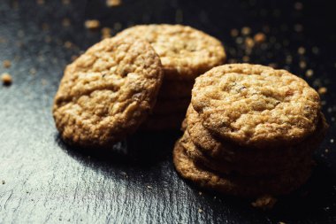 Bisküvi tatlı kurabiye arka plan. Yerli yığılmış tereyağı bisküvi desen kavramı, makro yakından. Ev yapımı kurabiye ahşap masa üzerinde. Mısır gevreği bisküvi susam, yer fıstığı, ayçiçeği ve amaranth.
