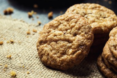 Bisküvi tatlı kurabiye arka plan. Yerli yığılmış tereyağı bisküvi desen kavramı, makro yakından. Ev yapımı kurabiye ahşap masa üzerinde. Mısır gevreği bisküvi susam, yer fıstığı, ayçiçeği ve amaranth.