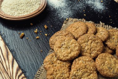 Bisküvi tatlı kurabiye arka plan. Yerli yığılmış tereyağı bisküvi desen kavramı, makro yakından. Ev yapımı kurabiye ahşap masa üzerinde. Mısır gevreği bisküvi susam, yer fıstığı, ayçiçeği ve amaranth.