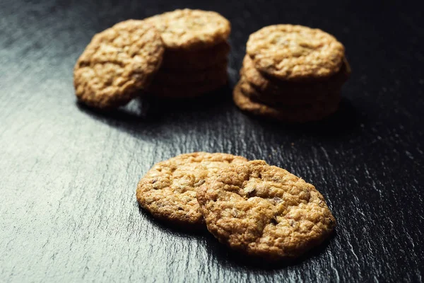 Bisküvi tatlı kurabiye arka plan. Yerli yığılmış tereyağı bisküvi desen kavramı, makro yakından. Ev yapımı kurabiye ahşap masa üzerinde. Mısır gevreği bisküvi susam, yer fıstığı, ayçiçeği ve amaranth.