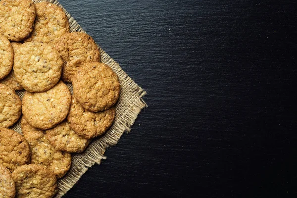 Bisküvi tatlı kurabiye arka plan. Yerli yığılmış tereyağı bisküvi desen kavramı, makro yakından. Ev yapımı kurabiye ahşap masa üzerinde. Mısır gevreği bisküvi susam, yer fıstığı, ayçiçeği ve amaranth.