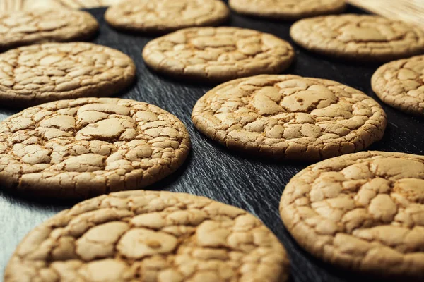 Bisküvi tatlı kurabiye arka plan. Yerli yığılmış tereyağı bisküvi desen kavramı, makro yakından. Ev yapımı kurabiye ahşap masa üzerinde. Mısır gevreği bisküvi susam, yer fıstığı, ayçiçeği ve amaranth.