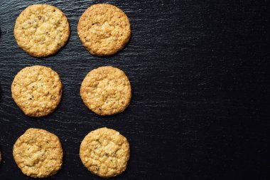 Bisküvi tatlı kurabiye arka plan. Yerli yığılmış tereyağı bisküvi desen kavramı, makro yakından. Ev yapımı kurabiye ahşap masa üzerinde. Mısır gevreği bisküvi susam, yer fıstığı, ayçiçeği ve amaranth.