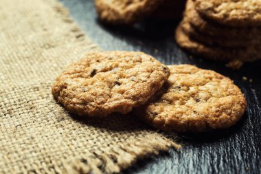 Bisküvi tatlı kurabiye arka plan. Yerli yığılmış tereyağı bisküvi desen kavramı, makro yakından. Ev yapımı kurabiye ahşap masa üzerinde. Mısır gevreği bisküvi susam, yer fıstığı, ayçiçeği ve amaranth.