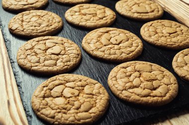 Bisküvi tatlı kurabiye arka plan. Yerli yığılmış tereyağı bisküvi desen kavramı, makro yakından. Ev yapımı kurabiye ahşap masa üzerinde. Mısır gevreği bisküvi susam, yer fıstığı, ayçiçeği ve amaranth.