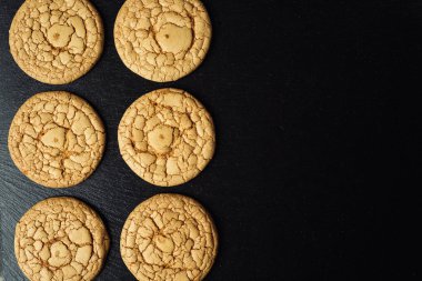 Bisküvi tatlı kurabiye arka plan. Yerli yığılmış tereyağı bisküvi desen kavramı, makro yakından. Ev yapımı kurabiye ahşap masa üzerinde. Mısır gevreği bisküvi susam, yer fıstığı, ayçiçeği ve amaranth.