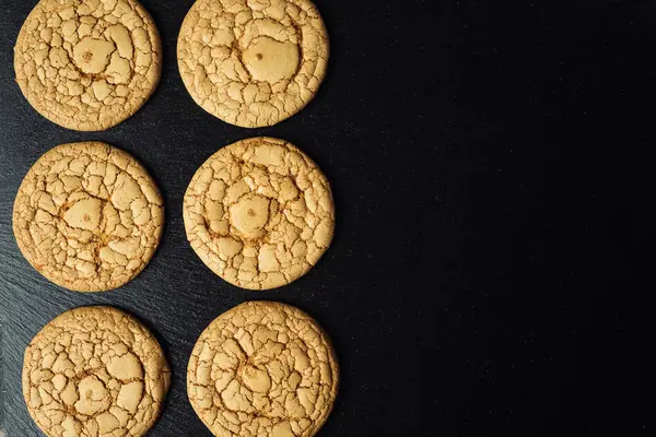 Bisküvi tatlı kurabiye arka plan. Yerli yığılmış tereyağı bisküvi desen kavramı, makro yakından. Ev yapımı kurabiye ahşap masa üzerinde. Mısır gevreği bisküvi susam, yer fıstığı, ayçiçeği ve amaranth.