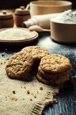 Bisküvi tatlı kurabiye arka plan. Yerli yığılmış tereyağı bisküvi desen kavramı, makro yakından. Ev yapımı kurabiye ahşap masa üzerinde. Mısır gevreği bisküvi susam, yer fıstığı, ayçiçeği ve amaranth.