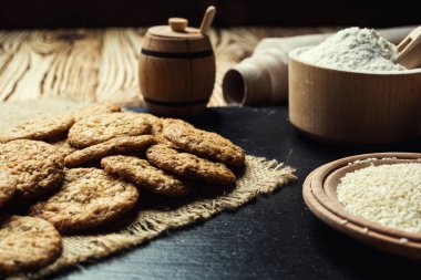 Bisküvi tatlı kurabiye arka plan. Yerli yığılmış tereyağı bisküvi desen kavramı, makro yakından. Ev yapımı kurabiye ahşap masa üzerinde. Mısır gevreği bisküvi susam, yer fıstığı, ayçiçeği ve amaranth.