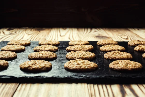 Bisküvi tatlı kurabiye arka plan. Yerli yığılmış tereyağı bisküvi desen kavramı, makro yakından. Ev yapımı kurabiye ahşap masa üzerinde. Mısır gevreği bisküvi susam, yer fıstığı, ayçiçeği ve amaranth.