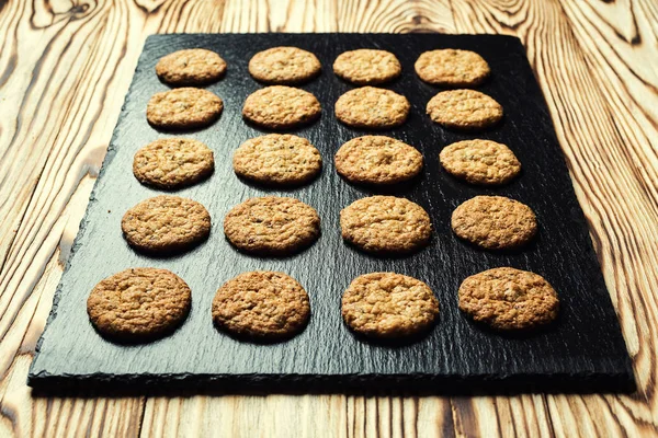 Bisküvi tatlı kurabiye arka plan. Yerli yığılmış tereyağı bisküvi desen kavramı, makro yakından. Ev yapımı kurabiye ahşap masa üzerinde. Mısır gevreği bisküvi susam, yer fıstığı, ayçiçeği ve amaranth.