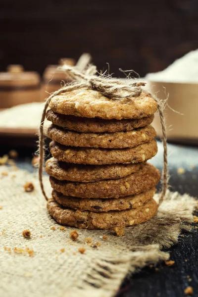 Bisküvi tatlı kurabiye arka plan. Yerli yığılmış tereyağı bisküvi desen kavramı, makro yakından. Ev yapımı kurabiye ahşap masa üzerinde. Mısır gevreği bisküvi susam, yer fıstığı, ayçiçeği ve amaranth.