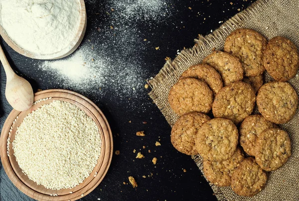 Bisküvi tatlı kurabiye arka plan. Yerli yığılmış tereyağı bisküvi desen kavramı, makro yakından. Ev yapımı kurabiye ahşap masa üzerinde. Mısır gevreği bisküvi susam, yer fıstığı, ayçiçeği ve amaranth.