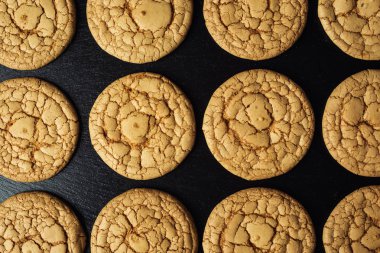 Bisküvi tatlı kurabiye arka plan. Yerli yığılmış tereyağı bisküvi desen kavramı, makro yakından. Ev yapımı kurabiye ahşap masa üzerinde. Mısır gevreği bisküvi susam, yer fıstığı, ayçiçeği ve amaranth.