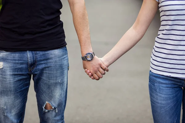Pasangan muda berjalan di taman dan berpegangan tangan, pasangan yang penuh kasih pergi pada piknik — Stok Foto