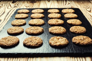 Bisküvi tatlı kurabiye arka plan. Yerli yığılmış tereyağı bisküvi desen kavramı, makro yakından. Ev yapımı kurabiye ahşap masa üzerinde. Mısır gevreği bisküvi susam, yer fıstığı, ayçiçeği ve amaranth.