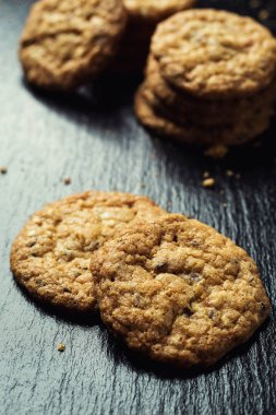 Bisküvi tatlı kurabiye arka plan. Yerli yığılmış tereyağı bisküvi desen kavramı, makro yakından. Ev yapımı kurabiye ahşap masa üzerinde. Mısır gevreği bisküvi susam, yer fıstığı, ayçiçeği ve amaranth.