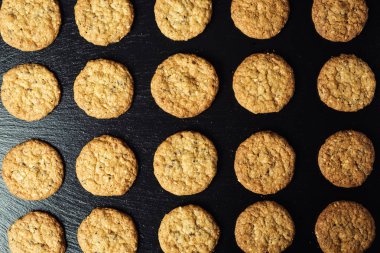 Bisküvi tatlı kurabiye arka plan. Yerli yığılmış tereyağı bisküvi desen kavramı, makro yakından. Ev yapımı kurabiye ahşap masa üzerinde. Mısır gevreği bisküvi susam, yer fıstığı, ayçiçeği ve amaranth.