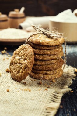 Bisküvi tatlı kurabiye arka plan. Yerli yığılmış tereyağı bisküvi desen kavramı, makro yakından. Ev yapımı kurabiye ahşap masa üzerinde. Mısır gevreği bisküvi susam, yer fıstığı, ayçiçeği ve amaranth.