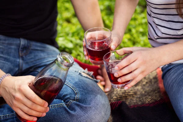 Man Pouring Juice In Glass For Young Woman,picnic summer concept,Handsome man pouring  juice in a glass