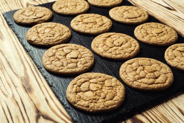 Bisküvi tatlı kurabiye arka plan. Yerli yığılmış tereyağı bisküvi desen kavramı, makro yakından. Ev yapımı kurabiye ahşap masa üzerinde. Mısır gevreği bisküvi susam, yer fıstığı, ayçiçeği ve amaranth.