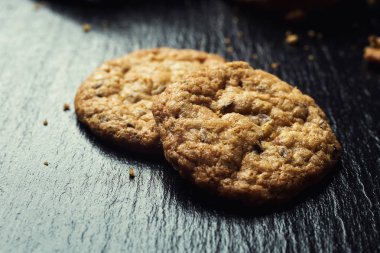 Bisküvi tatlı kurabiye arka plan. Yerli yığılmış tereyağı bisküvi desen kavramı, makro yakından. Ev yapımı kurabiye ahşap masa üzerinde. Mısır gevreği bisküvi susam, yer fıstığı, ayçiçeği ve amaranth.