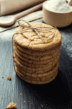 Bisküvi tatlı kurabiye arka plan. Yerli yığılmış tereyağı bisküvi desen kavramı, makro yakından. Ev yapımı kurabiye ahşap masa üzerinde. Mısır gevreği bisküvi susam, yer fıstığı, ayçiçeği ve amaranth.