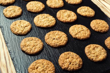 Bisküvi tatlı kurabiye arka plan. Yerli yığılmış tereyağı bisküvi desen kavramı, makro yakından. Ev yapımı kurabiye ahşap masa üzerinde. Mısır gevreği bisküvi susam, yer fıstığı, ayçiçeği ve amaranth.