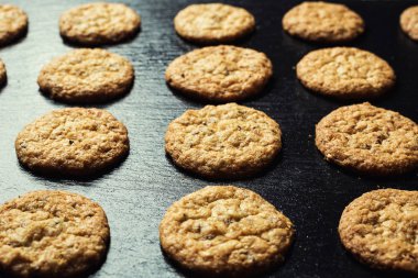 Bisküvi tatlı kurabiye arka plan. Yerli yığılmış tereyağı bisküvi desen kavramı, makro yakından. Ev yapımı kurabiye ahşap masa üzerinde. Mısır gevreği bisküvi susam, yer fıstığı, ayçiçeği ve amaranth.
