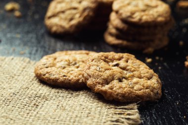 Bisküvi tatlı kurabiye arka plan. Yerli yığılmış tereyağı bisküvi desen kavramı, makro yakından. Ev yapımı kurabiye ahşap masa üzerinde. Mısır gevreği bisküvi susam, yer fıstığı, ayçiçeği ve amaranth.
