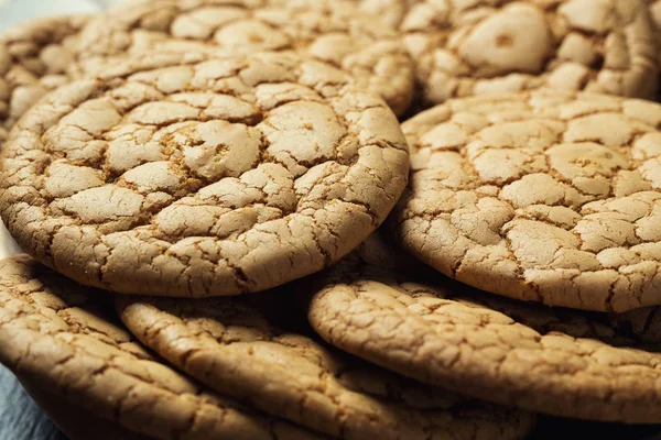 Bisküvi tatlı kurabiye arka plan. Yerli yığılmış tereyağı bisküvi desen kavramı, makro yakından. Ev yapımı kurabiye ahşap masa üzerinde. Mısır gevreği bisküvi susam, yer fıstığı, ayçiçeği ve amaranth.
