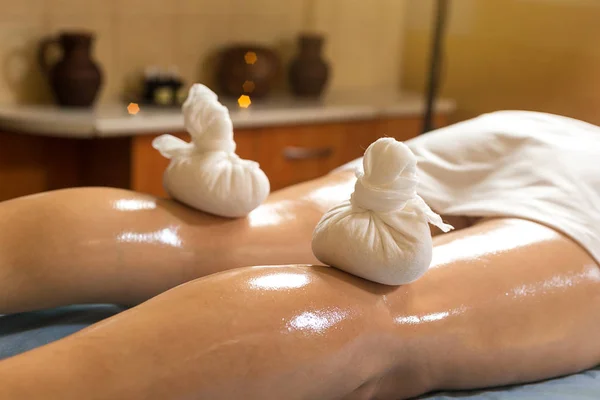 Woman in wellness beauty spa having aroma therapy massage with essential oil,Woman enjoying a Ayurveda oil massage treatment in a spa,Massage Techniques,Foot massage close-up, massage with pouches — Stock Photo, Image