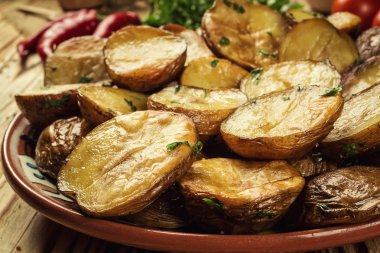 Sıcak buğulaması yakın fırında patates, sıcak tereyağlı ceket pişmiş patates, kavrulmuş patates kase ahşap masa üzerinde deniz tuzu ve biberiye, kızarmış patates fırında pişmiş patates otlar ile strewed.