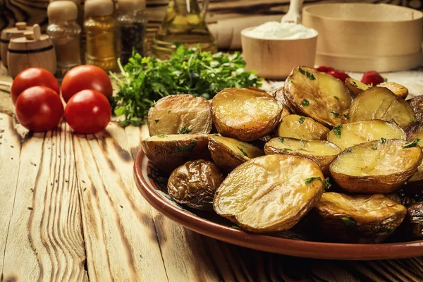 Sıcak buğulaması yakın fırında patates, sıcak tereyağlı ceket pişmiş patates, kavrulmuş patates kase ahşap masa üzerinde deniz tuzu ve biberiye, kızarmış patates fırında pişmiş patates otlar ile strewed.