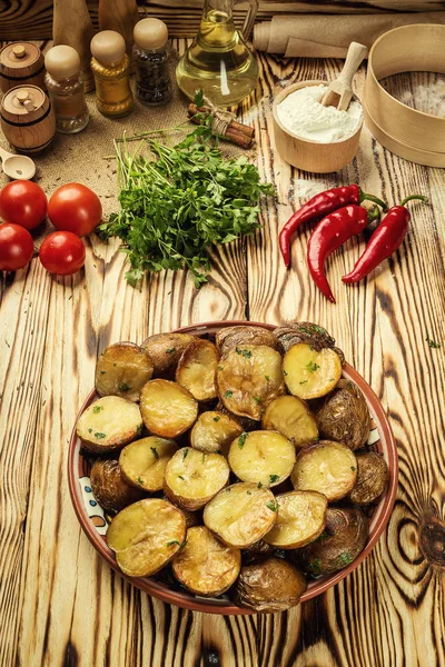 Close up of steaming hot baked potato,Hot buttered jacket baked potatoes,Roasted potato in bowl on wooden table,Oven-baked potatoes with sea salt and rosemary,toasted baked potato strewed with herbs.