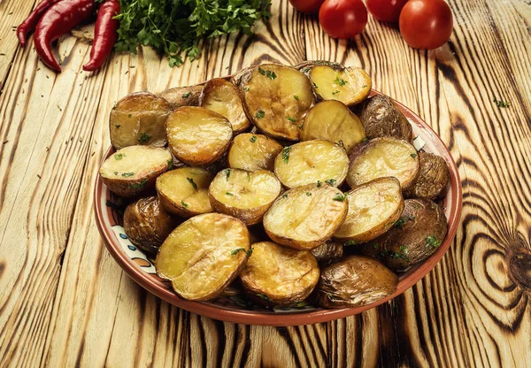 Sıcak buğulaması yakın fırında patates, sıcak tereyağlı ceket pişmiş patates, kavrulmuş patates kase ahşap masa üzerinde deniz tuzu ve biberiye, kızarmış patates fırında pişmiş patates otlar ile strewed.