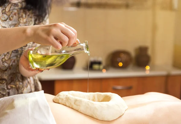 Femme dans le spa de bien-être ayant massage aromatique avec huile essentielle, Femme bénéficiant d'un traitement de massage à l'huile ayurvédique dans un spa, Techniques de massage, massage du dos, Fille salon de massage aux herbes ayurvédiques — Photo