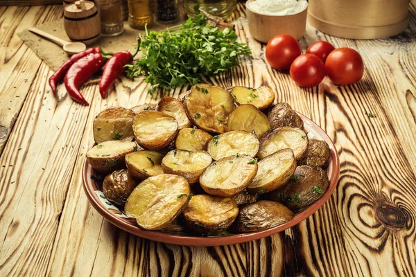Sıcak buğulaması yakın fırında patates, sıcak tereyağlı ceket pişmiş patates, kavrulmuş patates kase ahşap masa üzerinde deniz tuzu ve biberiye, kızarmış patates fırında pişmiş patates otlar ile strewed.