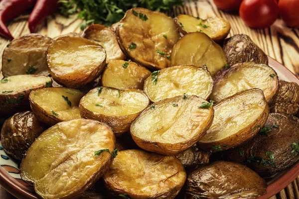 Közelről a gőzölgő forró sült burgonya, forró vajas kabát sült burgonya, sült burgonya tálba a fából készült asztal, kemencében sült burgonyával, tengeri sóval, rozmaringgal, pirított sült burgonya testét, kiterítvén a gyógynövények. — Stock Fotó