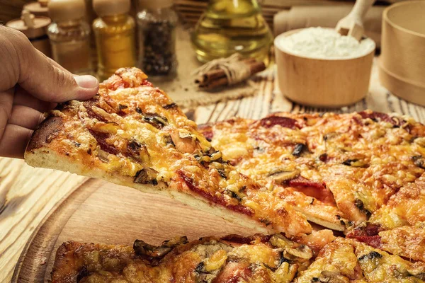 Hot pizza slice with melting cheese on a rustic wooden table.pepperoni pizza,Hot Homemade Pepperoni Pizza Ready to Eat,Supreme Pizza lifted slice,Delicious cheese stringy slice lifted of full supreme pizza,Margherita
