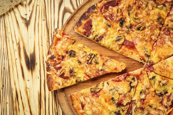 Hot pizza slice with melting cheese on a rustic wooden table.pepperoni pizza,Hot Homemade Pepperoni Pizza Ready to Eat,Supreme Pizza lifted slice,Delicious cheese stringy slice lifted of full supreme pizza,Margherita